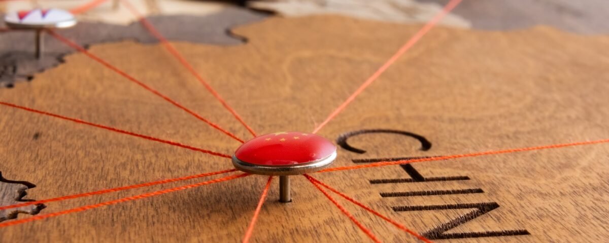 China flag on the pushpin and red threads on the wooden map